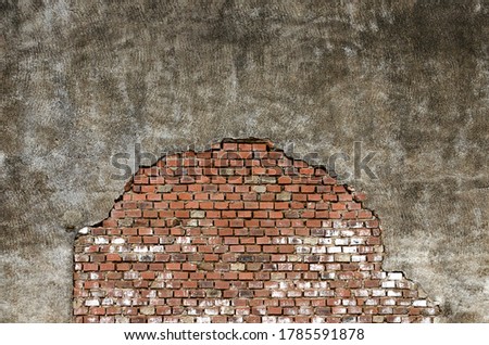 Old gray wall with partly exposed bricks 