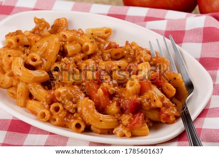 A delicious meal of elbow macaroni with pasta sauce tomatoes and hamburger