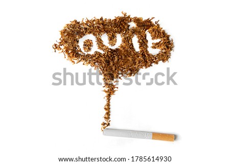 Quit smoking concept. Close up of a cigarette with quit smoking word made of dried tobacco on the table. Isolated on white background
