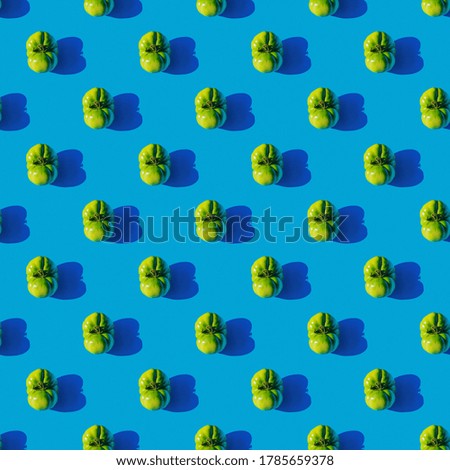 Pattern of green tomatoes on a blue background. Seamless texture