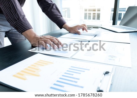 The hands of a male businessman are analyzing and calculating the annual income and expenses in a financial graph that shows results To summarize balances overall in office.