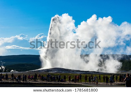 Visitors enjoy watching Old Faithful Geyser erupt in Yellowstone National Park