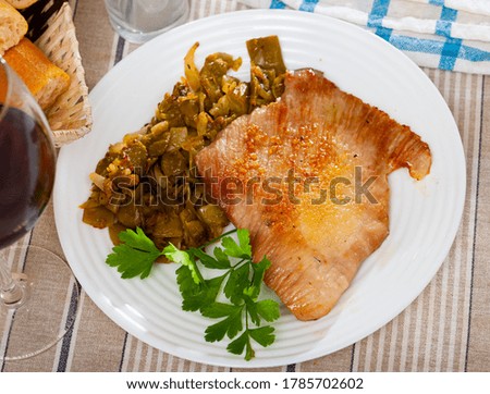 Close-up fried pork meat chops with stewed beans at plate