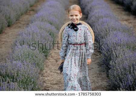 Charming caucasian girl walking in a lavender field during a sunset, summer