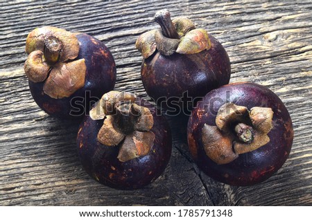 Fresh mangosteen fruit on old wooden board