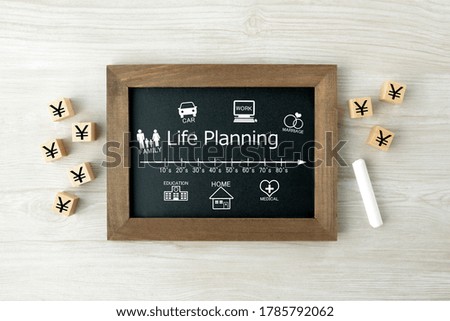 Life planning scale with life events pictogram on blackboard and wooden blocks with Japanese yen mark