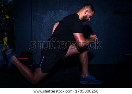 Man does crossfit push ups with trx fitness straps in the gym's studio. High resulotion image.