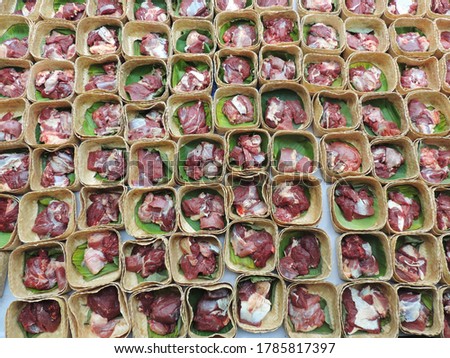 Muslims prepare halal slaughtering during Eid Al-Adha Al Mubarak, the Feast of Sacrifice or Qurban distribution meat wrapped in woven bamboo without using plastic bags Royalty-Free Stock Photo #1785817397
