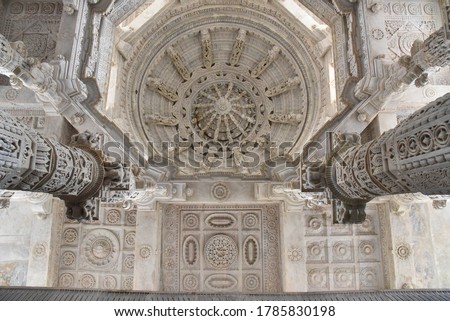 White pink marble stone carvings of ceiling of Jain temple mandir depicting religious murals in Ranakpur Chaumukha temple, Rajasthan, India Royalty-Free Stock Photo #1785830198