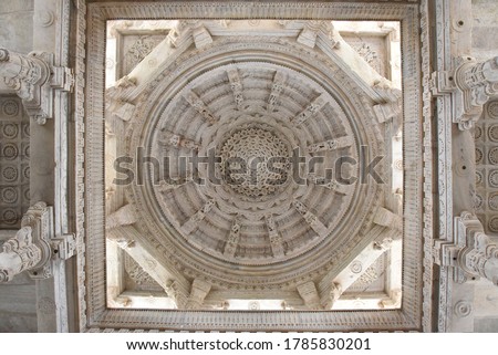 White pink marble stone carvings of ceiling of Jain temple mandir depicting religious murals in Ranakpur Chaumukha temple, Rajasthan, India Royalty-Free Stock Photo #1785830201