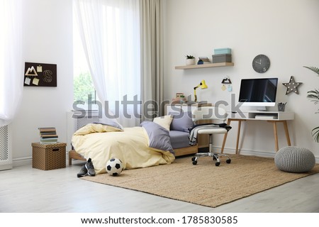Stylish teenager's room interior with comfortable bed and workplace Royalty-Free Stock Photo #1785830585