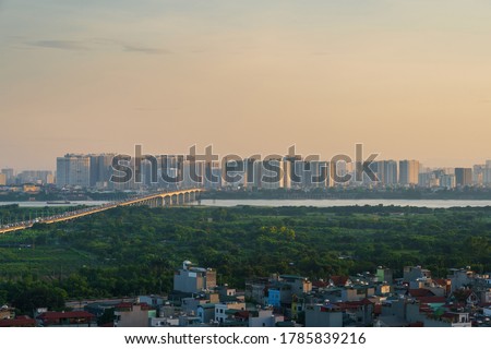 Cityscape of Hanoi skyline at Vinh Tuy bridge over Red river during sunset time