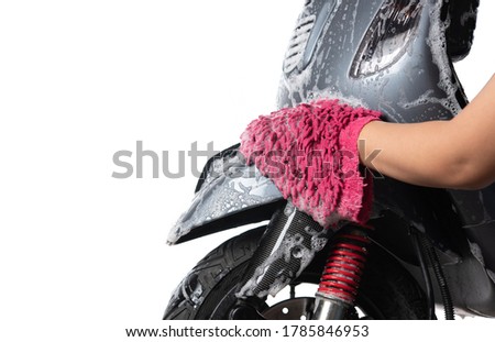 Hand washing a motorcycle or motor scooter isolated on white background