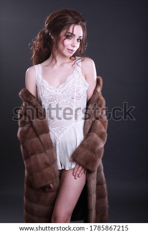 Beautiful girl with professional makeup and curly hairstyle in brown fur coat and underwear.  Stylish Woman in Luxury Fashion Fur Coat. Fashion model posing in a mink fur coat. Winter fur coat concept