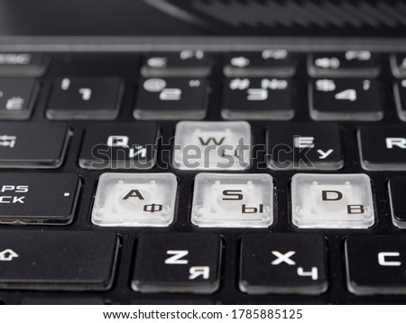 fashionable backlit laptop keyboard on dark background