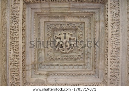White pink marble stone carvings of ceiling of Jain temple mandir depicting religious murals in Ranakpur Chaumukha temple, Rajasthan, India Royalty-Free Stock Photo #1785919871