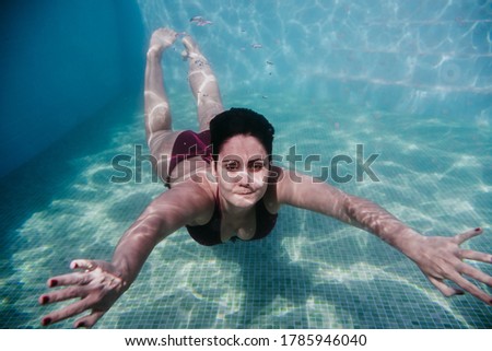young woman diving underwater in a pool. summer and fun lifestyle