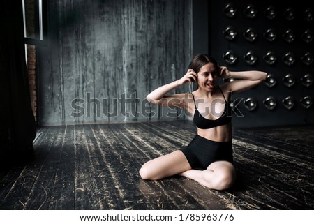Asian young brunette listens to meditation music and exercises from the basic yoga course for sports and relaxation.