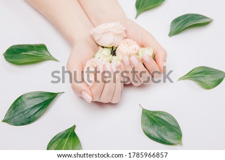 Beautiful stylish trendy female pink manicure with flower on background, top view. Concept beauty.
