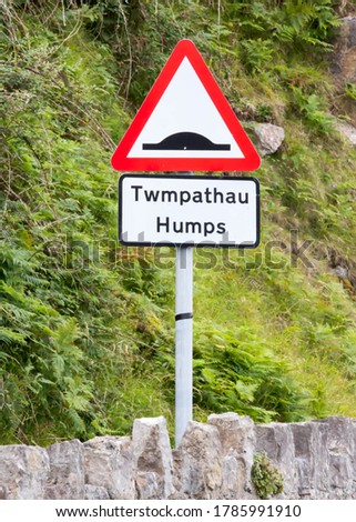 Warning sign about speed humps on the road written in both Engish and Welsh.