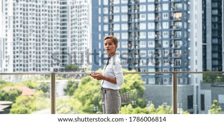 Business woman on building roof with city view using digital tablet stock photo