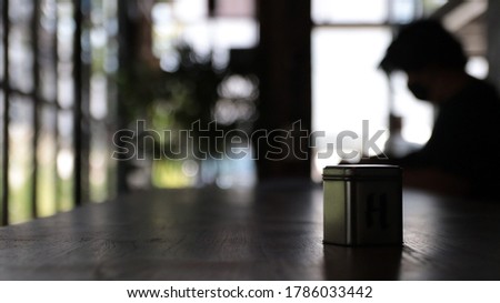 Square boxes placed on the table, men sitting in cafes.