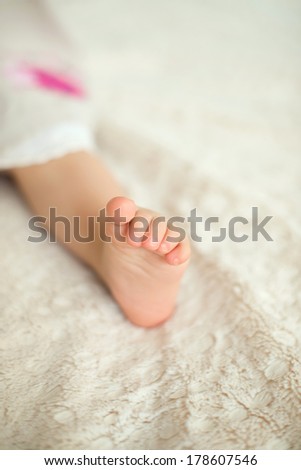 child's foot on bed at home