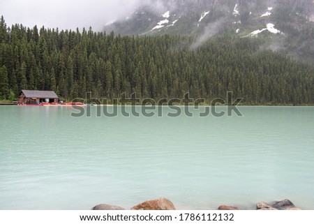 A picture of lake Louise and mountains taken on a rainy morning.   