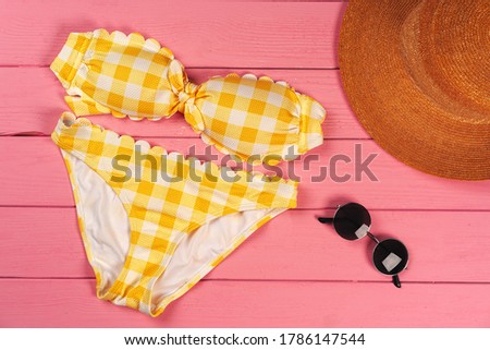 Yellow bikini on bright pink wooden background