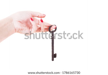 Female hand holds an old key. Isolated on a white background.
