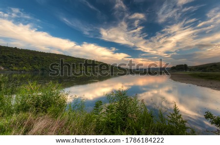 Magical Sunset Over the Riveer. Colorful sky under sunlit reflected in water. Wonderful Natural Background, view with Dramatic sky