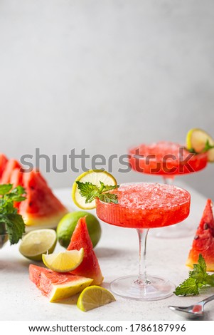 Watermelon frozen cocktail margarita with fresh watermelon, lime and mint on white background