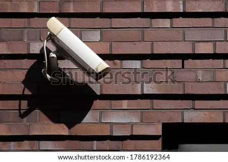 Surveillance camera on the outside wall of a building symbolizing state supervision