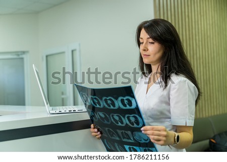 Female doctor holding a picture of a brain MRI workflow in diagnostic hospital. Healthcare, roentgen, people and medicine concept.
