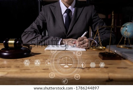Law and Legal services concept, Good service cooperation, lawyer man working on wood table office, law virtual screen interface icons, Background toned image blurred.