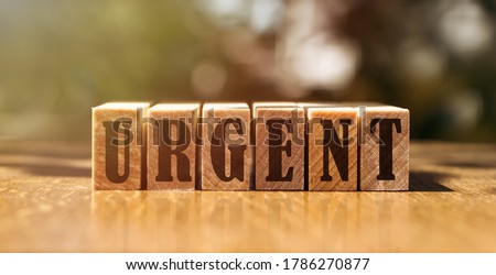Urgent word written on wooden blocks. Urgent care text on wooden table for your desing, concept