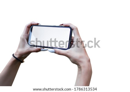 Girl Hand holding the black Mockup smartphone with isolated screen and beautiful nails. Mock-up Technology