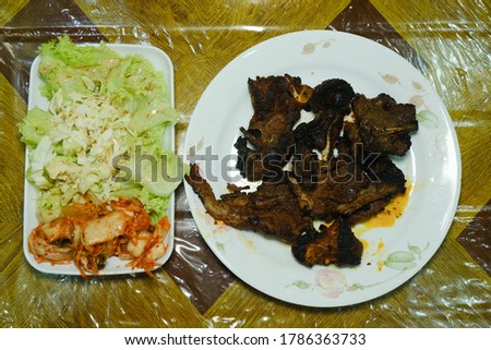 A picture of black pepper barbecue grilled lamb serve with salad and kimchi on table.