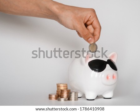  investing in a financial airbag for a future good life. hand holding a piggy bank white background coins