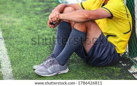 Soccer football referee takes a break from the match  at the grass of stadium