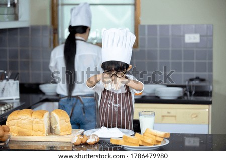 Happy Asian boy having breakfast with preparing food in the kitchen.