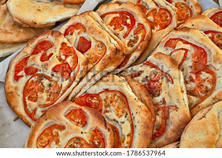 Italian food: traditional focaccia, schiacciata of Tuscany, a flat oven-baked bread product with olive oil and tomato, very popular in Italy. Similar to pizza doughs but more soft and thick