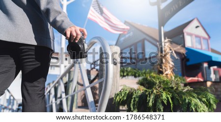 closeup asian woman hand hold retro camera traveller with background of old tradition architecture and us flag,asian photograper travel with retro camera