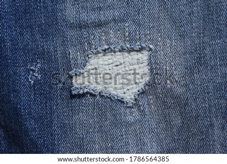 Hole on Denim torn Jeans. Ripped Destroyed Torn Blue jeans
