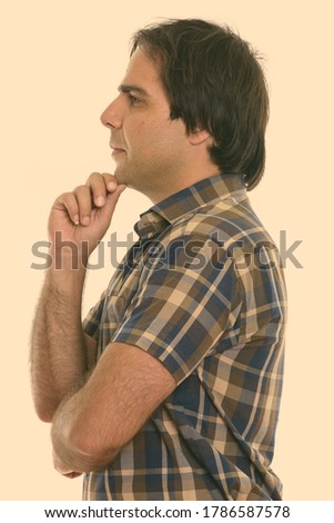 Profile view of young Persian man thinking