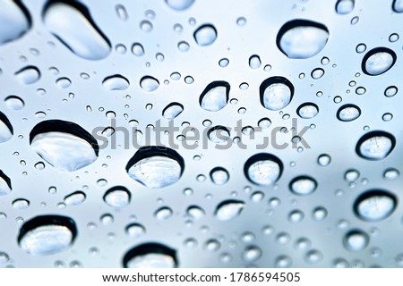 Close up of natural water drops on glass texture. Car windshield wipers on in the rainy weather.