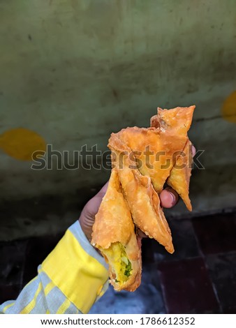 A samosa is an Indian food consisting of vegetables, spices, and sometimes meat, wrapped in pastry and fried. micro image microchrome image samose  Royalty-Free Stock Photo #1786612352