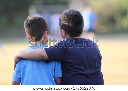 Two boys friends holding each other, outdoors Royalty-Free Stock Photo #1786622378