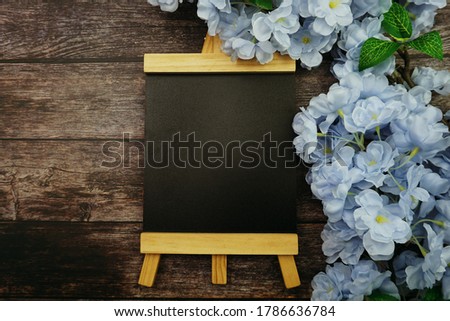 Empty Easel Space copy for text with Blooming flowers on wooden background