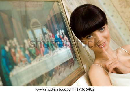 mysterious bride is standing near picture with smile